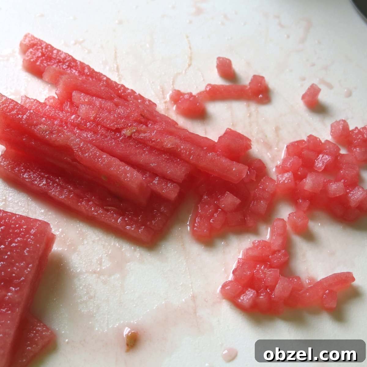 Long skinny rectangular pieces of watermelon partially diced.