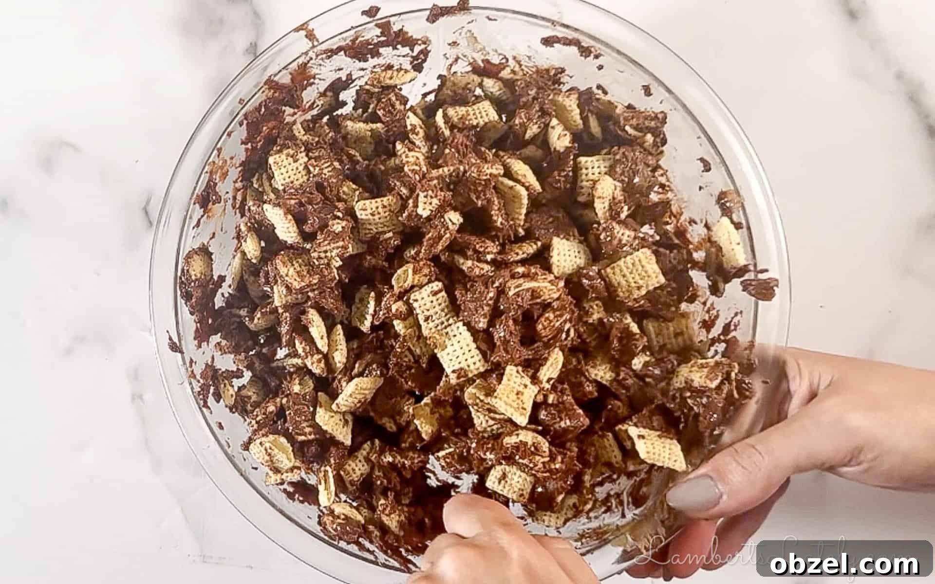 No Bake Muddy Buddy Cookies 5 adding chex to the chocolate mixture in the bowl.