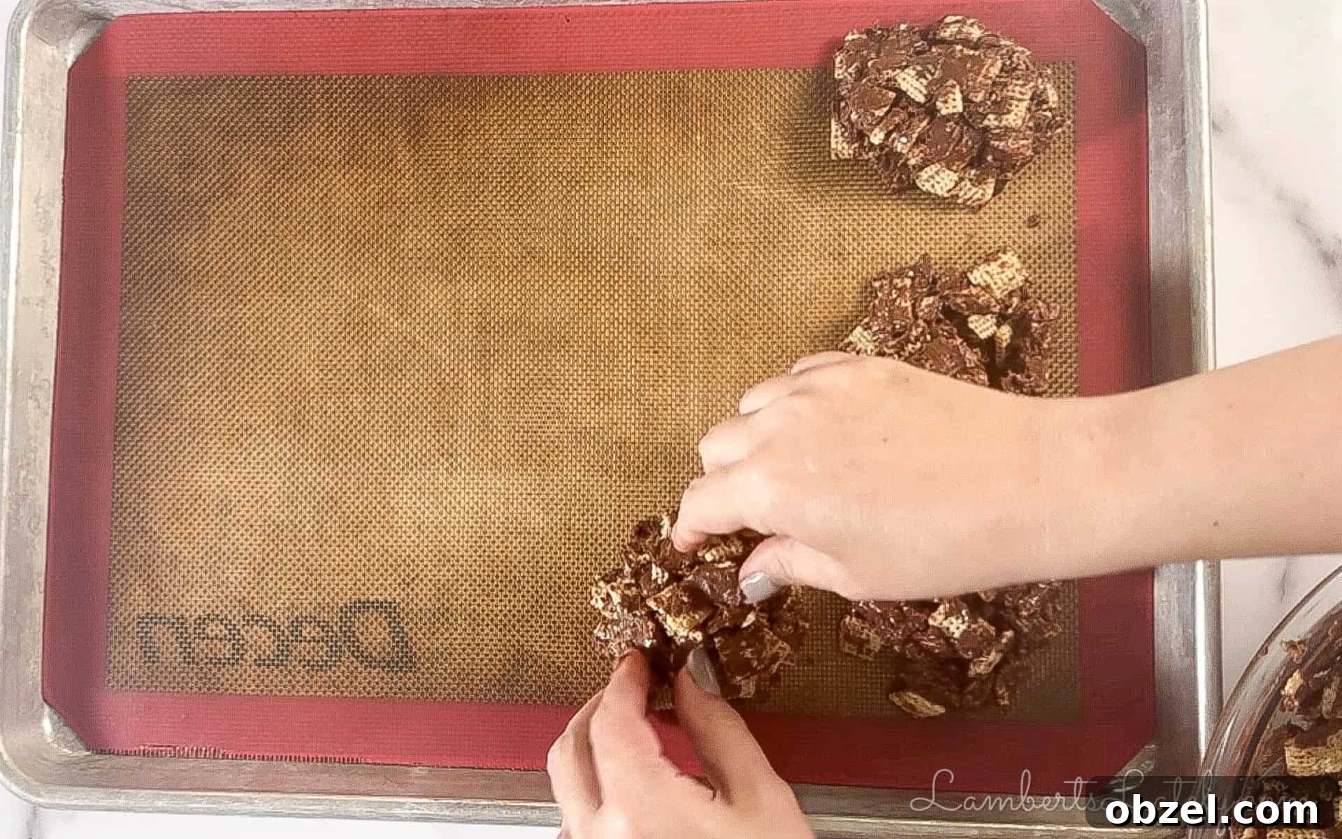 No Bake Muddy Buddy Cookies 6 forming chocolate chex mixture into cookies on a baking sheet.