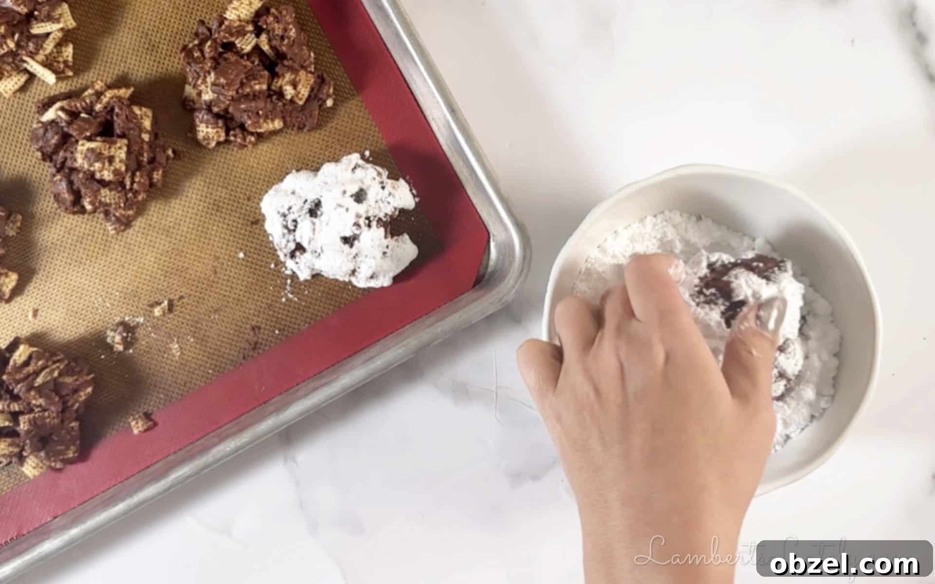 No Bake Muddy Buddy Cookies 7 rolling formed cookies in powdered sugar.