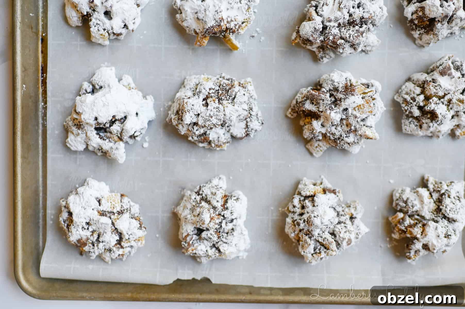 No Bake Muddy Buddy Cookies 8 muddy buddy cookies on a sheet pan.