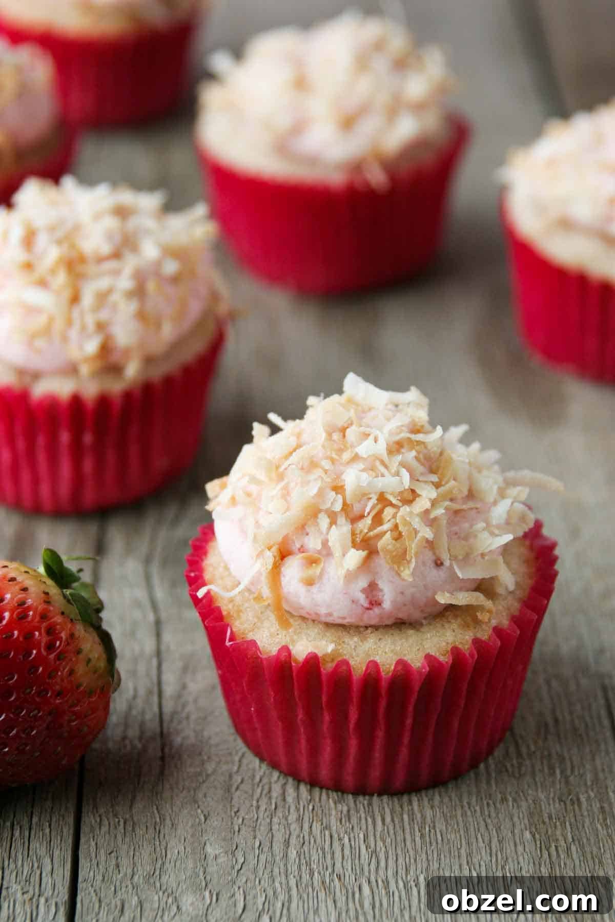 Strawberry, coconut and pineapple cupcakes topped with coconut frosting and toasted coconut