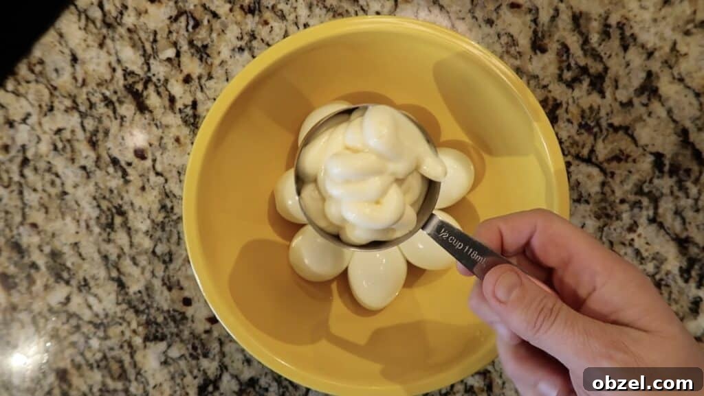 Adding mayonnaise to bowl
