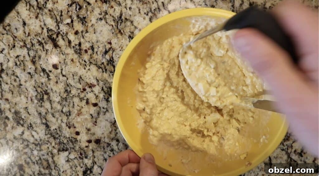 Using potato masher to mash up egg salad