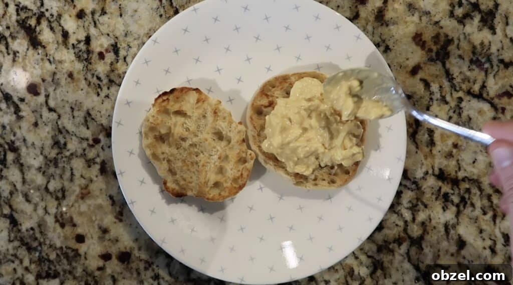 Spooning egg salad onto English muffins