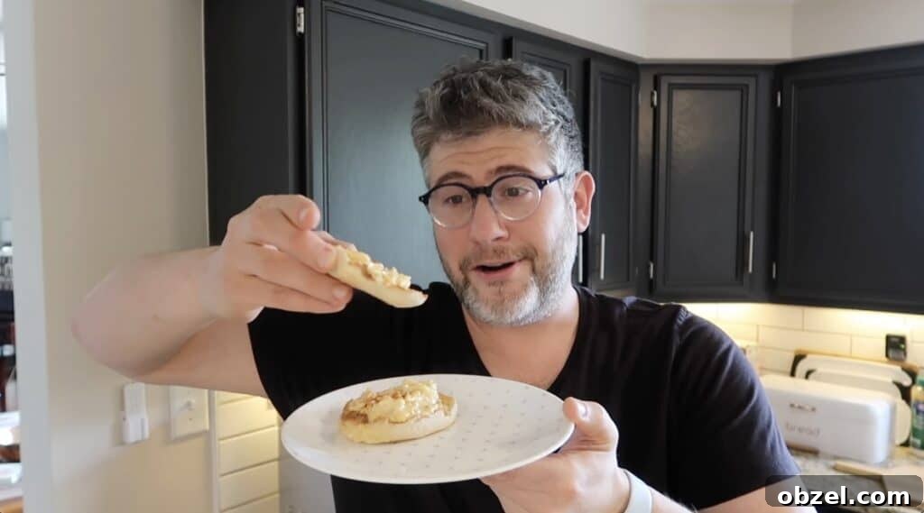 Man holding English muffin with deviled egg salad on it