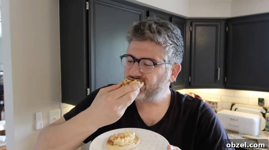 Man biting into English muffin with deviled egg salad