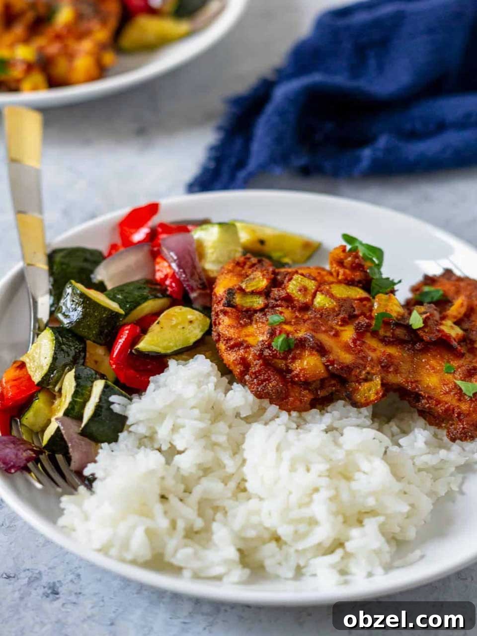 15 Air Fryer Chicken Thigh Recipes for Crispy, Juicy Results 12 One chicken thigh on top of white rice with mixed vegetables alongside.