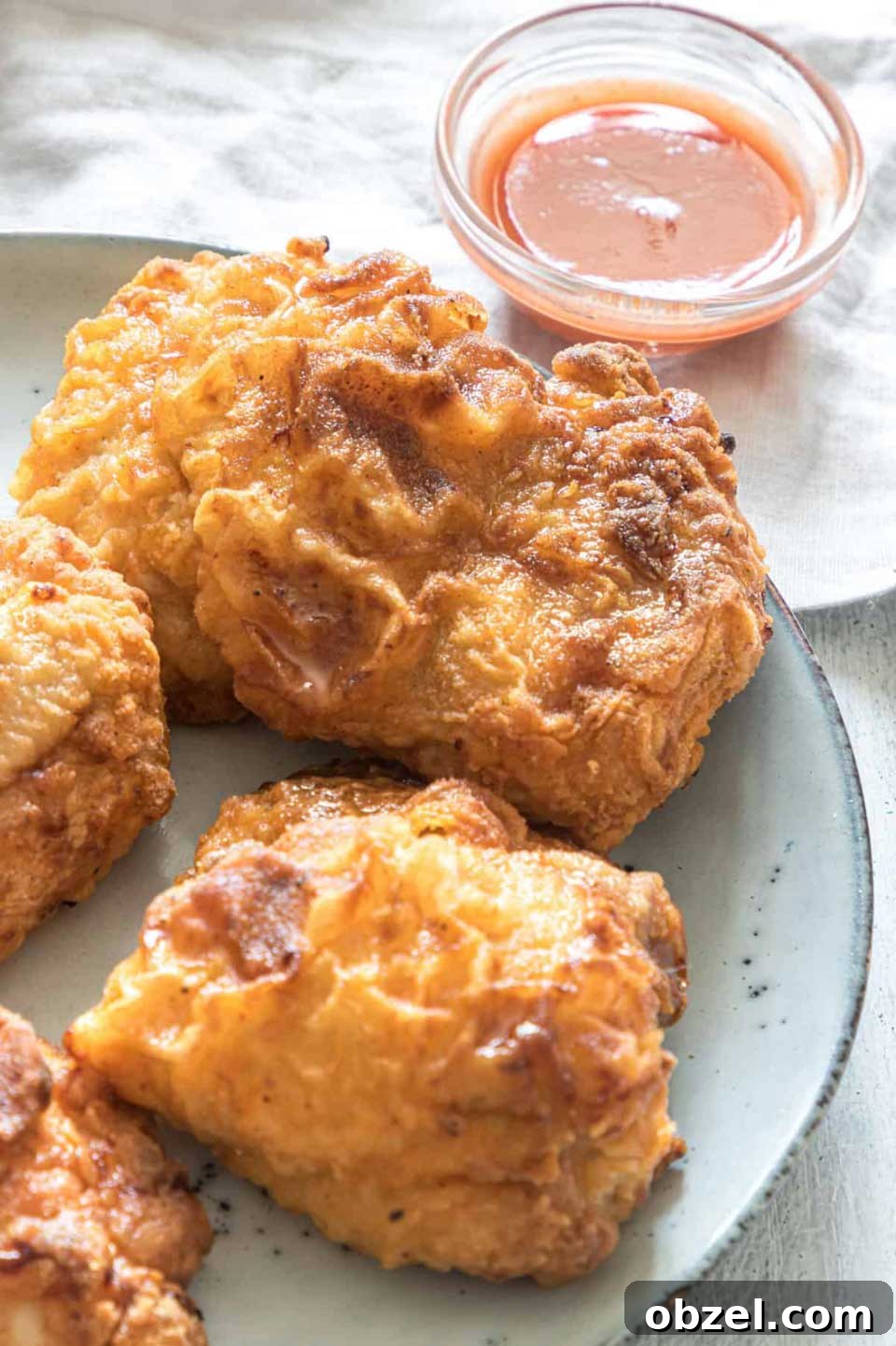 15 Air Fryer Chicken Thigh Recipes for Crispy, Juicy Results 3 Gray serving plate of chicken with dipping sauce behind.