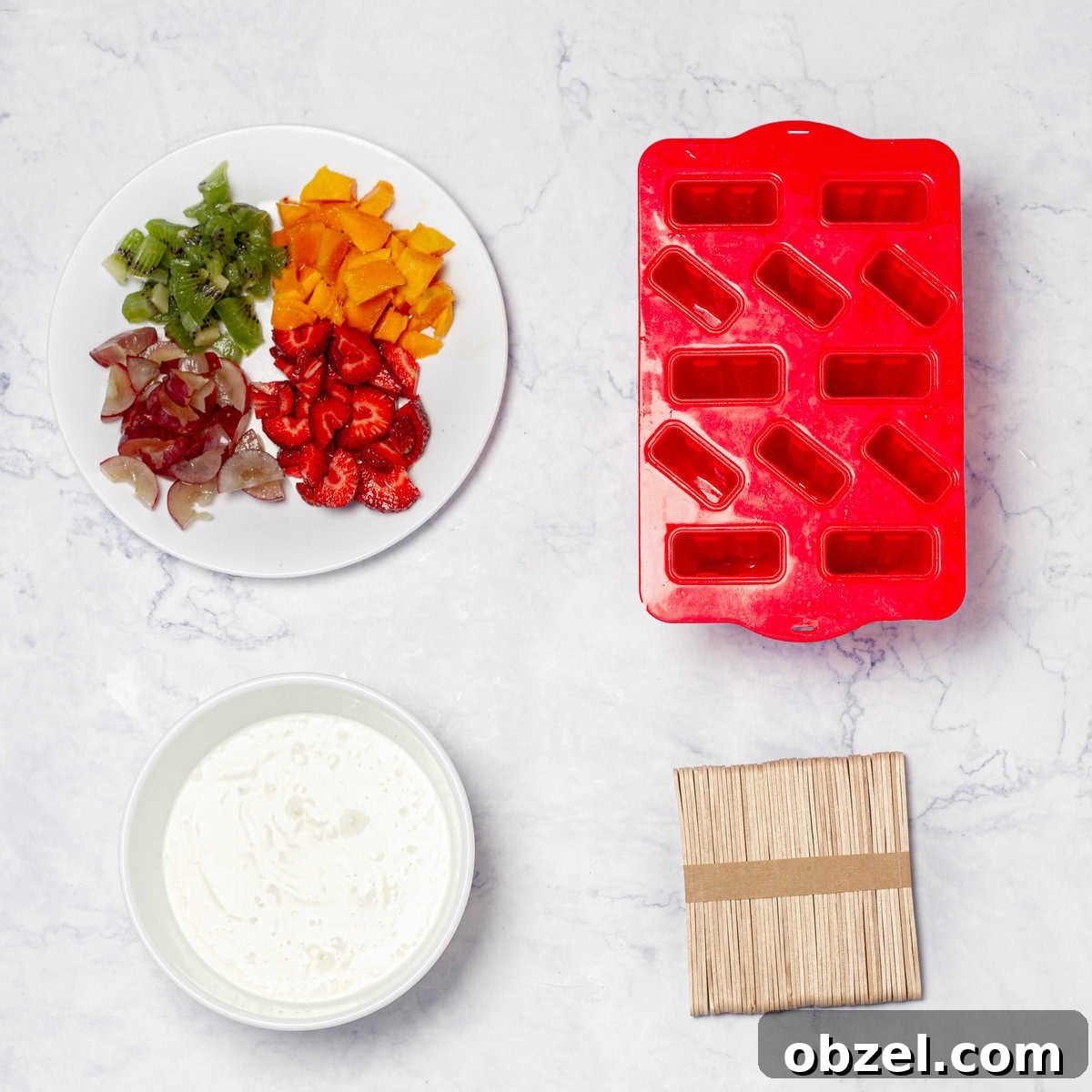 Low-Point Yogurt and Fruit Ice Pops | WW Points 3 Fruit and yogurt ice pop ingredients of chopped fruit and Greek yogurt in separate dishes next to popsicle molds and popsicle sticks.