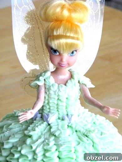 Tinker Bell Tea Party: Decorations, Games and Treats 3 tinkerbell toy covered in frosting for tinkerbell cake