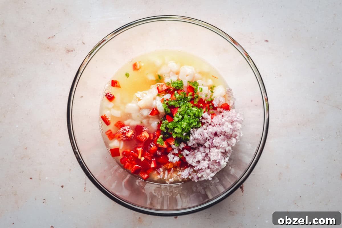 Citrus Scallop Ceviche Recipe with Lime and Fresh Herbs 5 Adding jalapeño to scallop mix in a glass bowl.