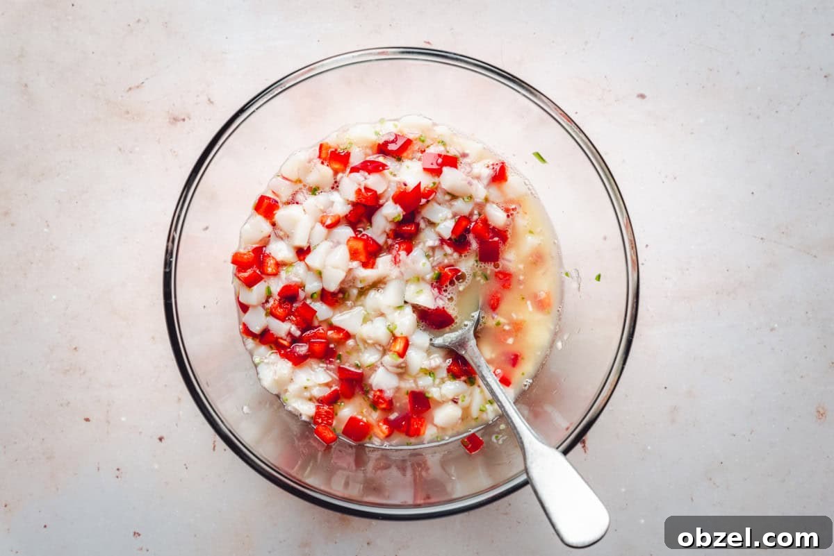 Citrus Scallop Ceviche Recipe with Lime and Fresh Herbs 6 Mixing ingredients of scallop ceviche in a glass bowl.