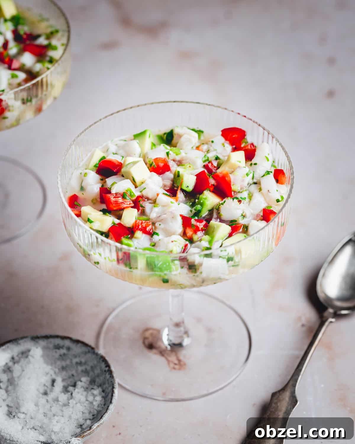 Citrus Scallop Ceviche Recipe with Lime and Fresh Herbs 10 Scallop ceviche in a coupe glass with serving spoon.