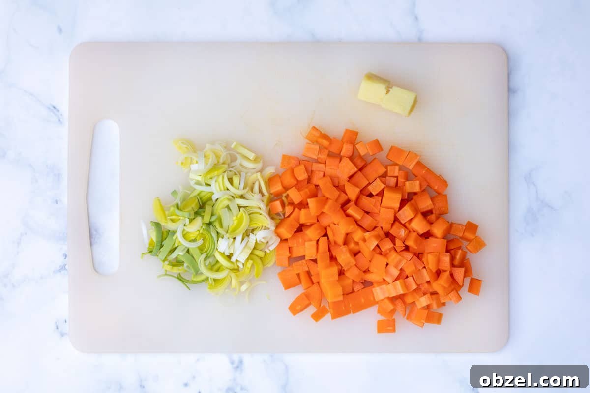 chopped carrots, sliced leeks, and ginger on cutting board