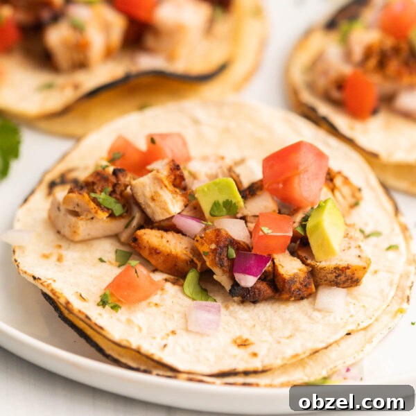 Grilled Chopped Chicken on tortillas topped with dice onion, avocado and tomatoes