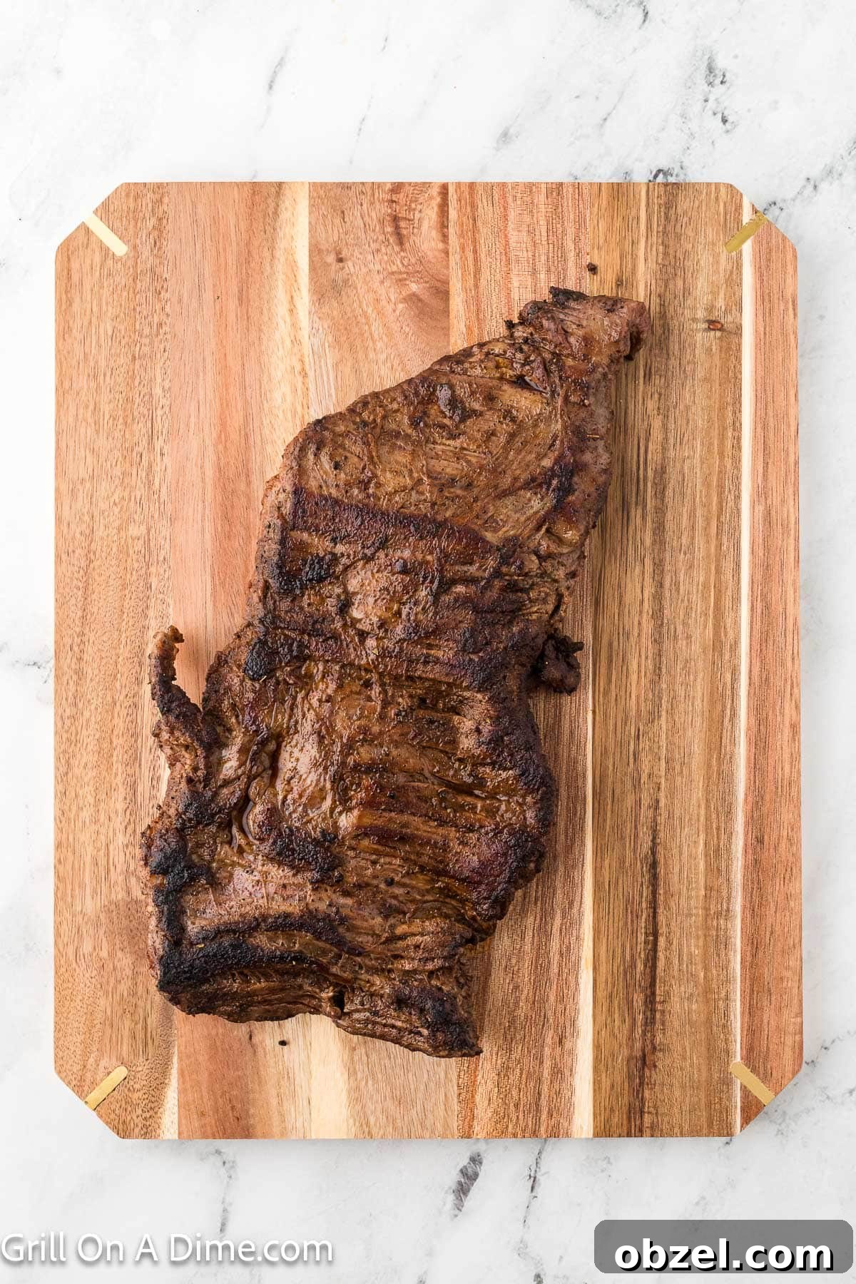 Juicy Blackstone Steak Tacos with Charred Onions and Lime 7 Cooked steak on a cutting board