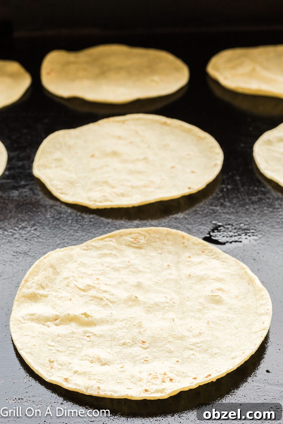 Juicy Blackstone Steak Tacos with Charred Onions and Lime 8 Heating tortilla on the Blackstone Griddle