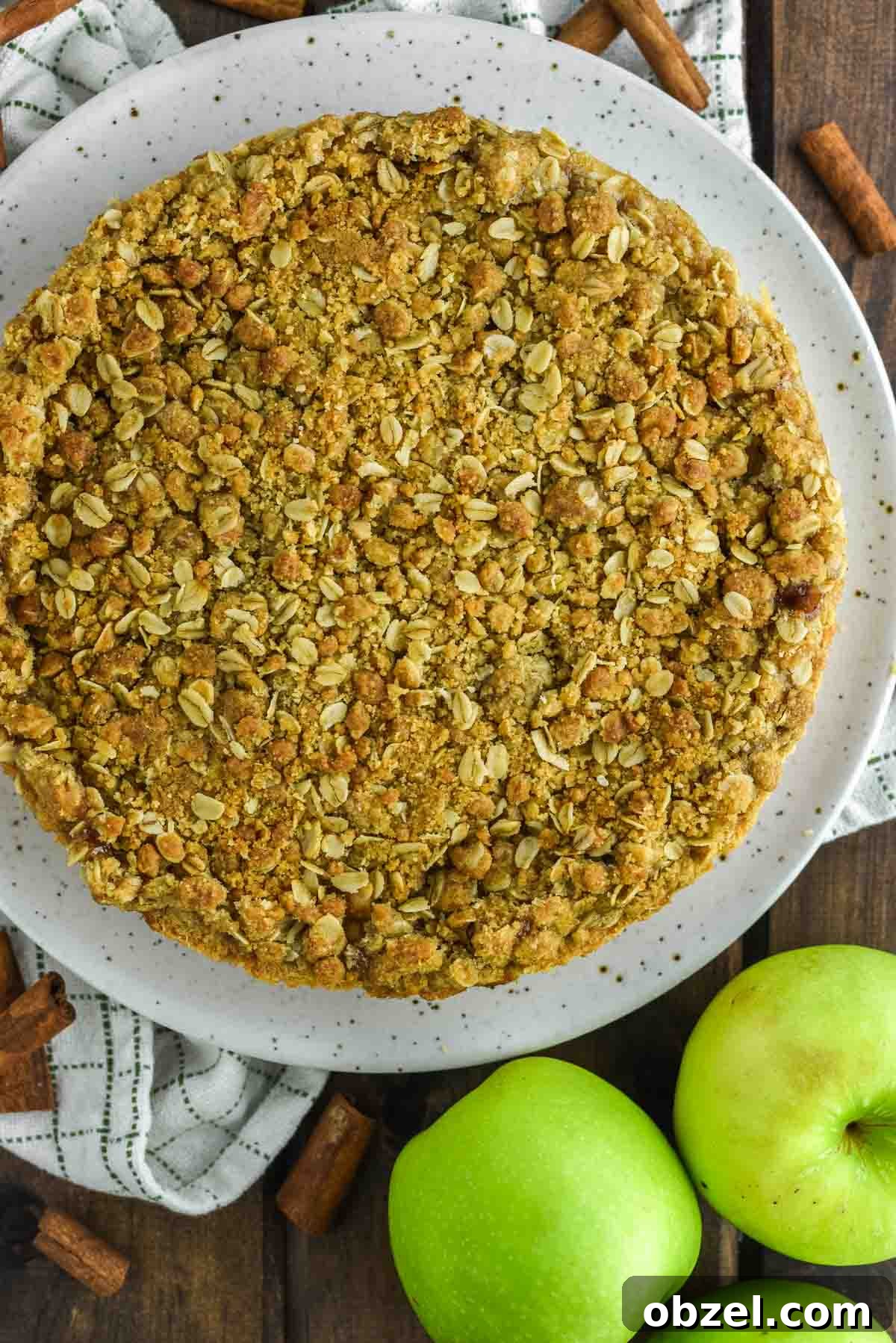 Apple crumble tart on speckled plate.