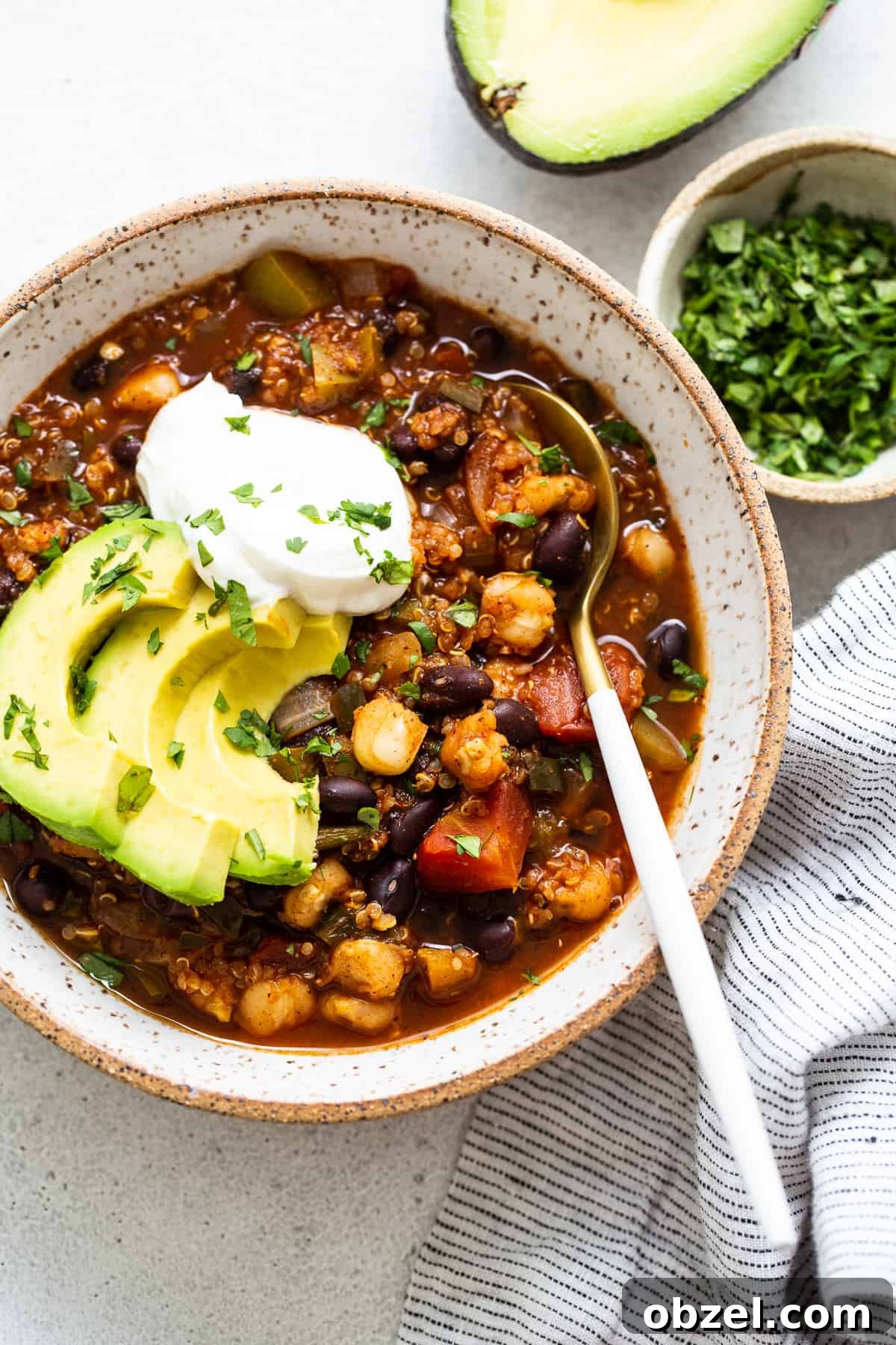 quinoa chili topped with avocado and sour cream.