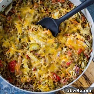 One Skillet Stuffed Cabbage Casserole Recipe 8 Overhead shot of cabbage casserole in a large shallow pot with a black spatula all resting on a wooden surface.