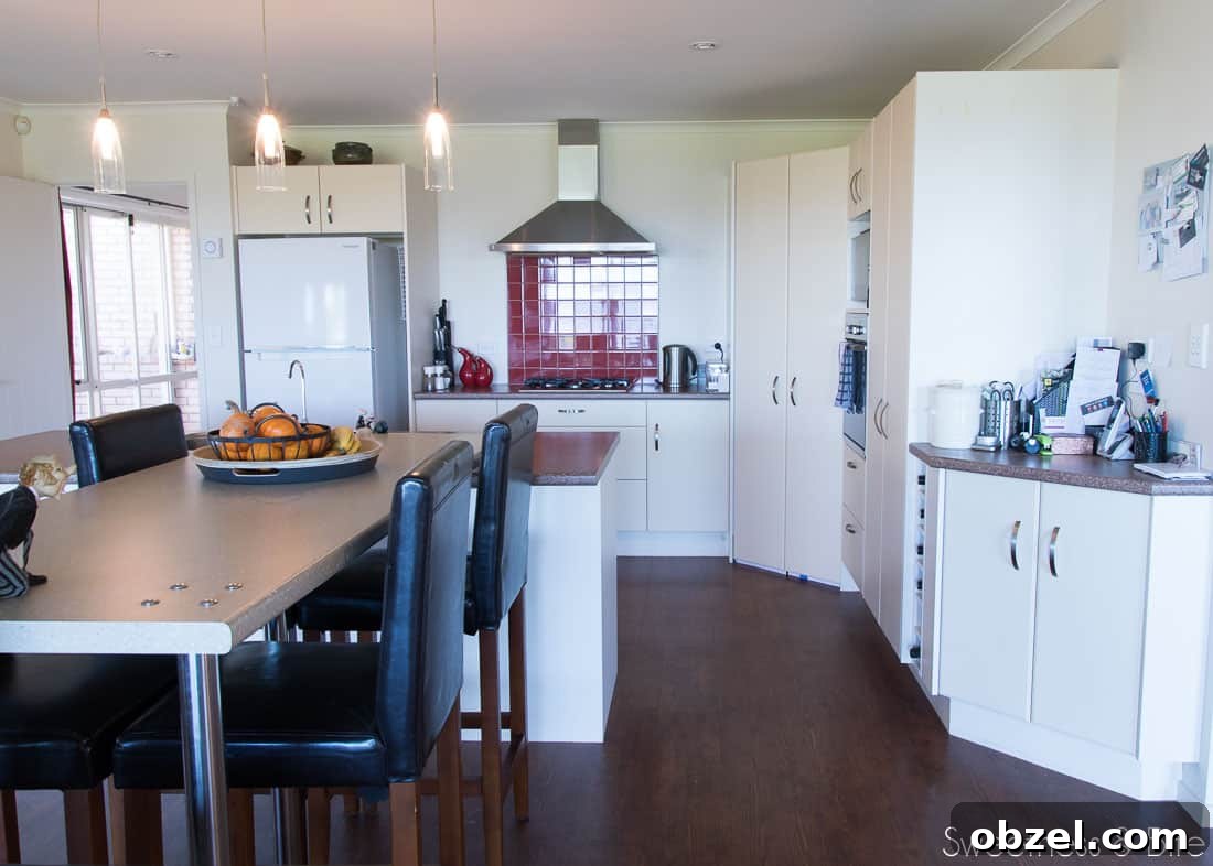 Kitchen Renovation and New Cake Pantry Reveal 5 An ugly old kitchen with a red tile splashback, a very small bench, a long, too high breakfast bar, and a gas fireplace at the end (view from the opposite side.)