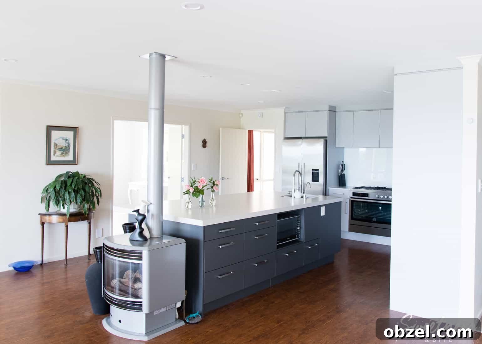 Kitchen Renovation and New Cake Pantry Reveal 7 A kitchen with light and dark grey cabinetry and a very wide and long island bench, with a gas fireplace at one end.