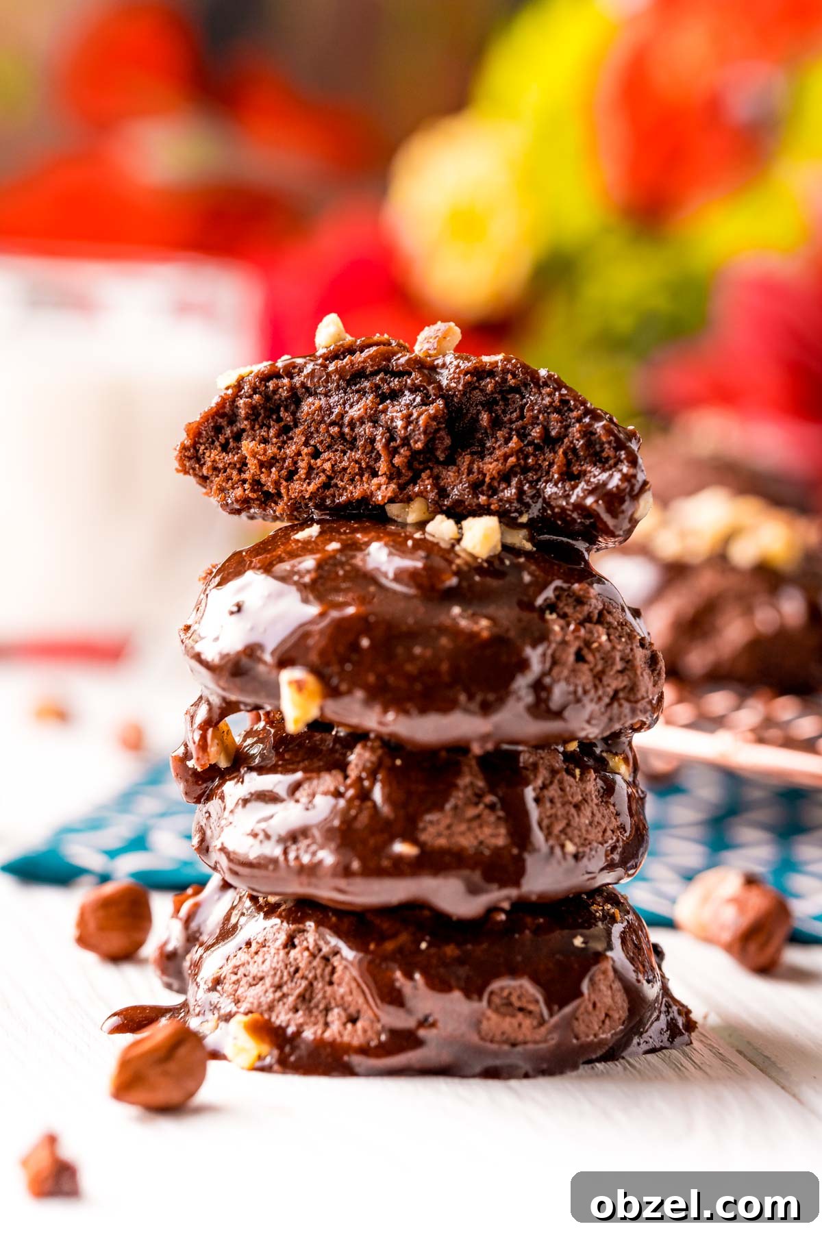Texas Sheet Cake Cookies with Fudgy Chocolate Frosting 3 Stack of Texas sheet cake cookies on a white table with the top one missing a bite.