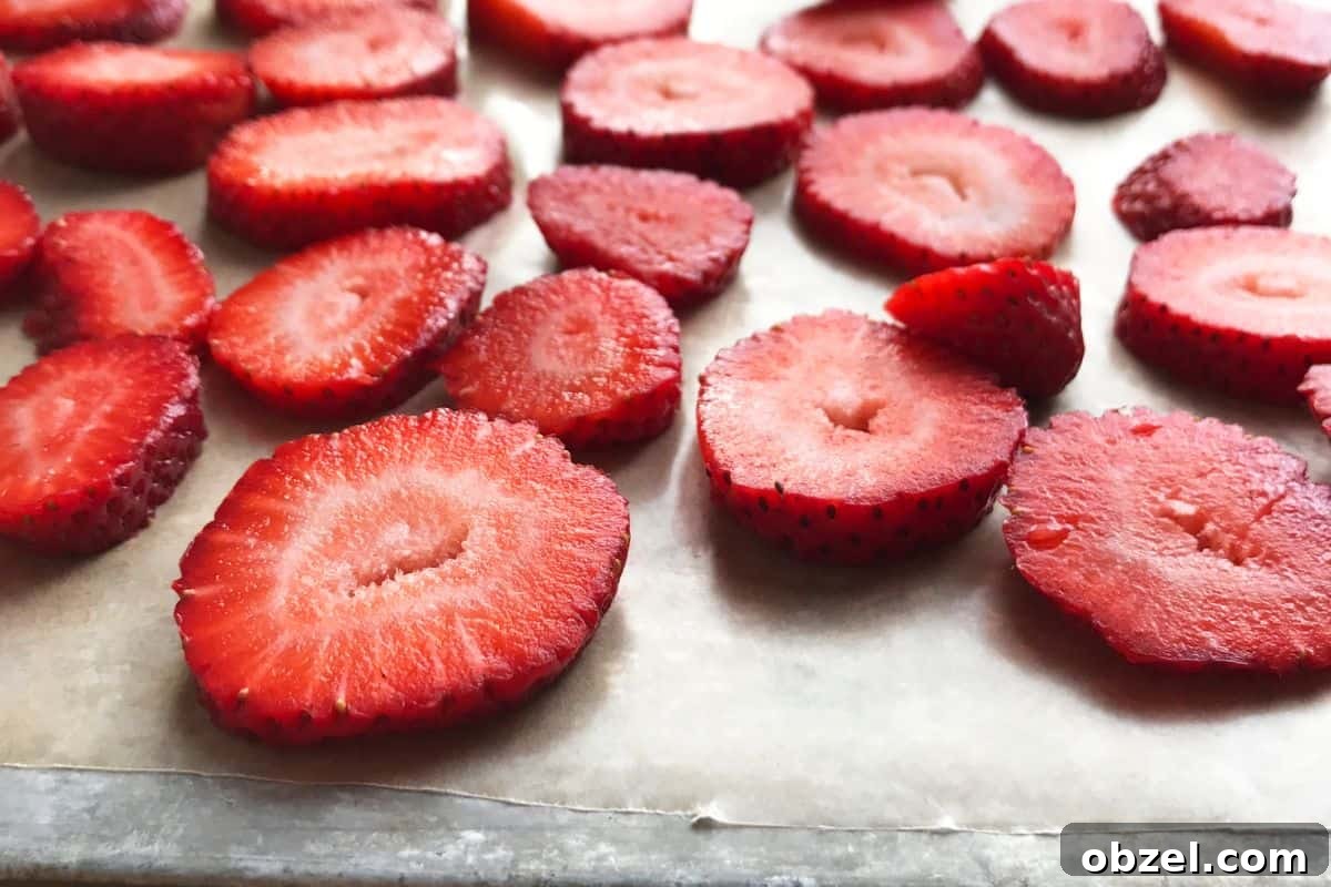 Homemade Strawberry Puree for Babies 7 strawberries on a sheet tray covered in parchment paper