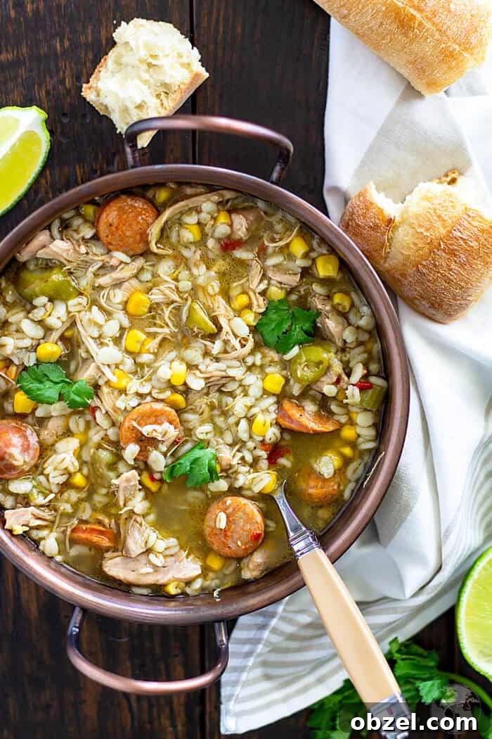 Cajun Chicken and Barley Gumbo Recipe 2 Gumbo soup in a copper bowl with a spoon and bread pieces.