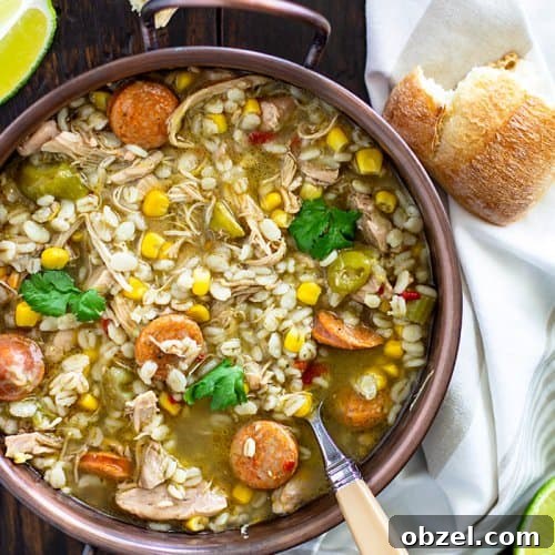 Cajun Chicken and Barley Gumbo Recipe 3 Gumbo soup in a copper bowl with a spoon and bread pieces.