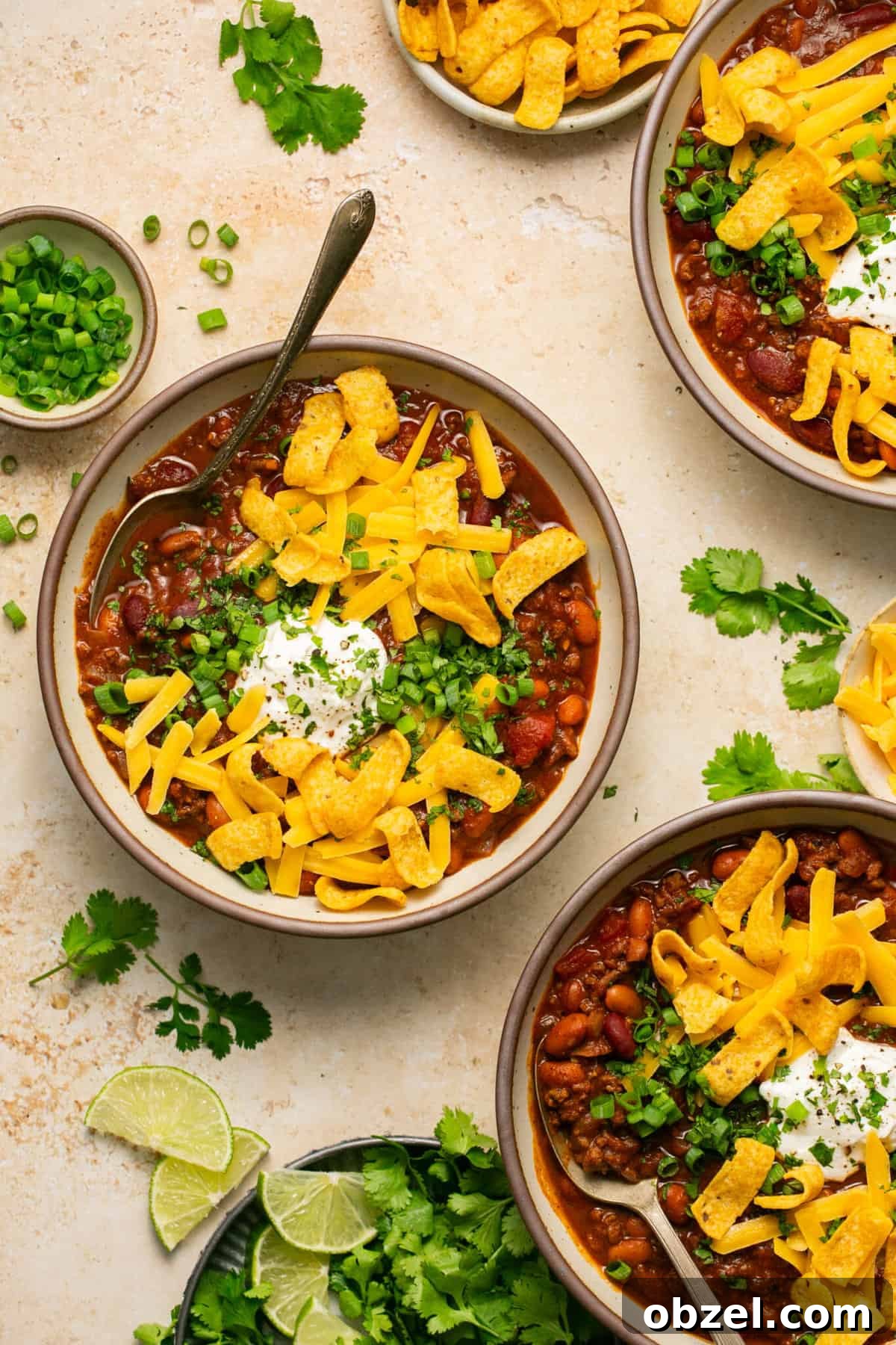 beef chili with cheese and fritos in bowls