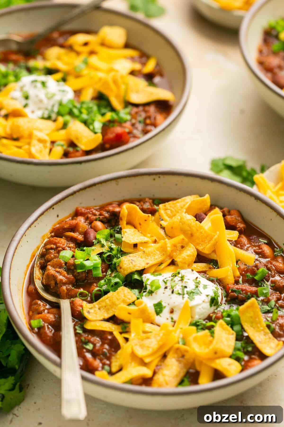 beef chili with cheese and fritos in bowls
