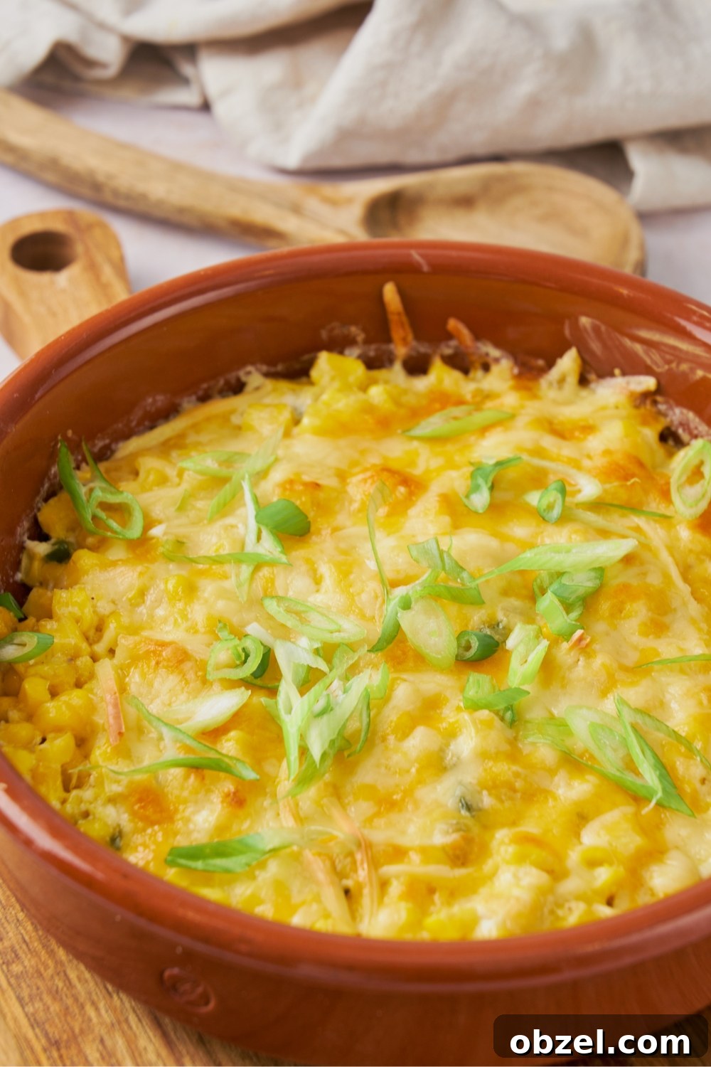 Jalapeno Corn Casserole with Cheddar 3 Melted cheese on top of jalapeno corn casserole in a red dish