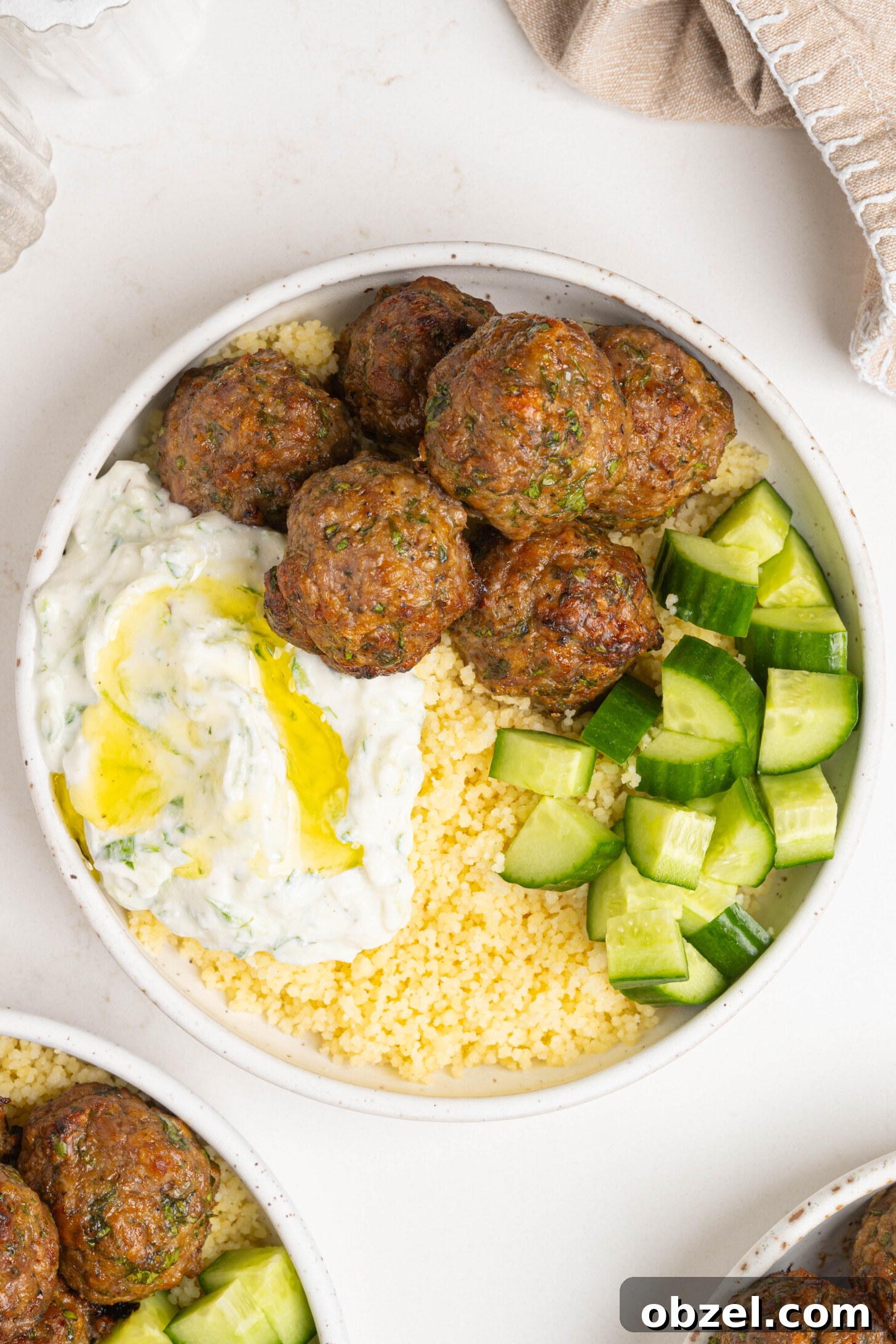 Tender Juicy Baked Moroccan Lamb Meatballs 3 A bowl of couscous, lamb meatballs, and more.