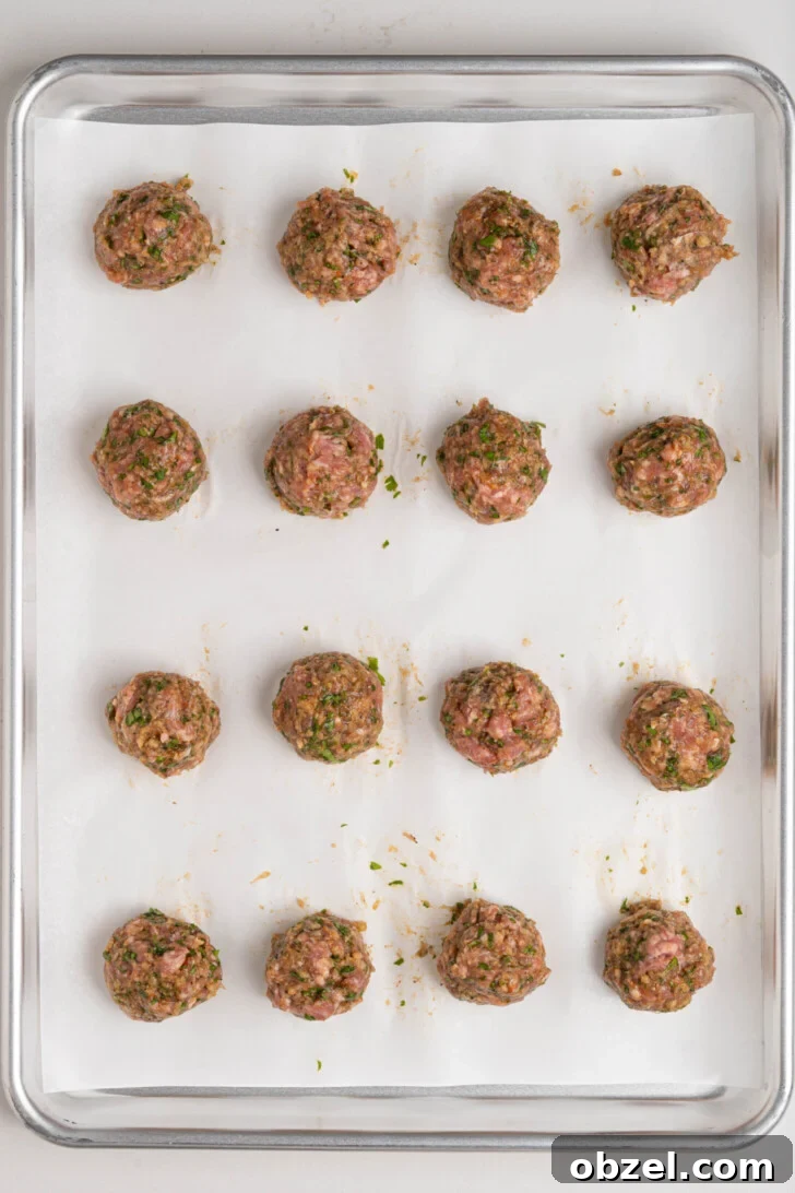 Tender Juicy Baked Moroccan Lamb Meatballs 8 Lamb meatballs on a baking sheet.