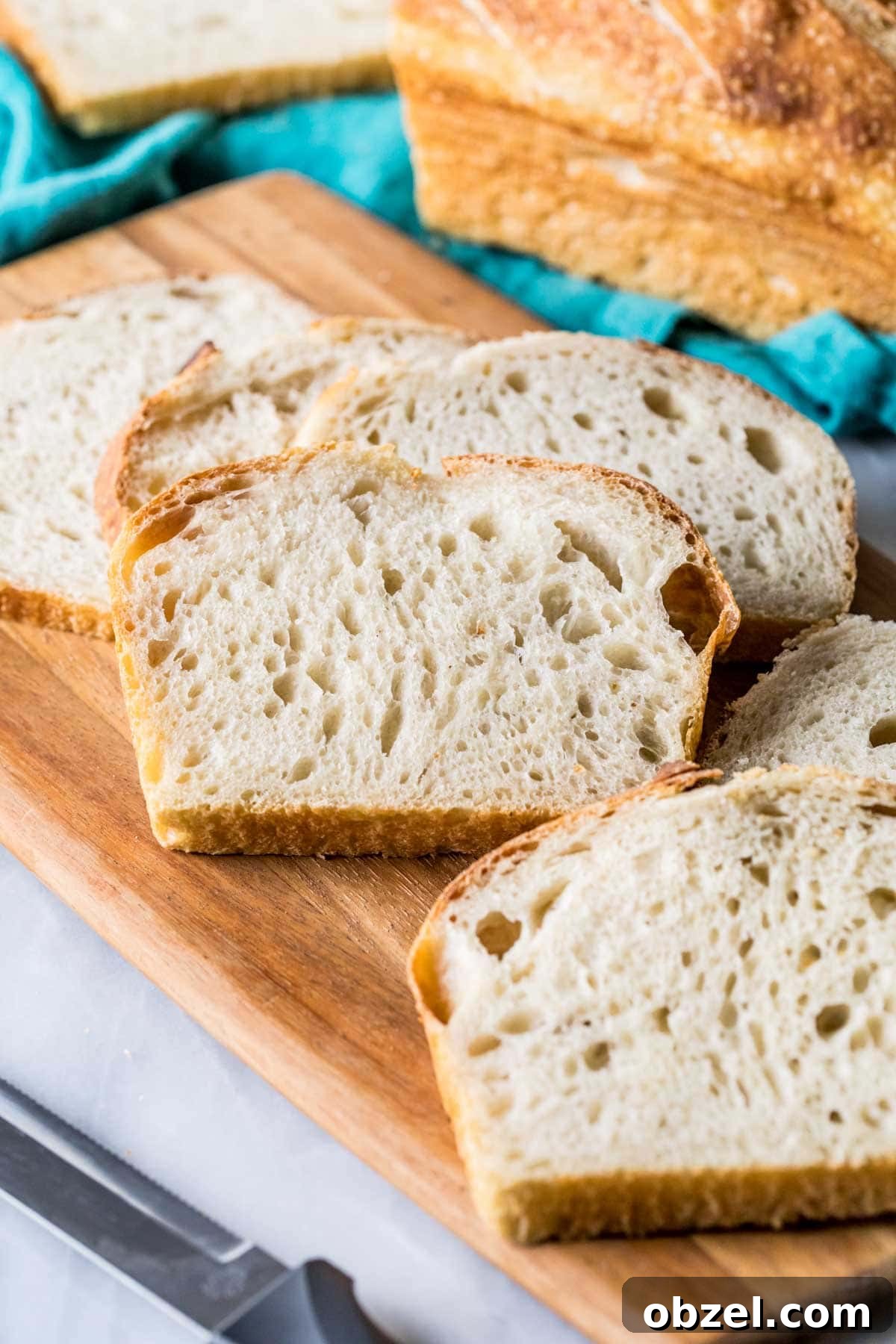 Homemade Sourdough Bread Recipe with Starter 11 Slices of sourdough bread on a wood cutting board.