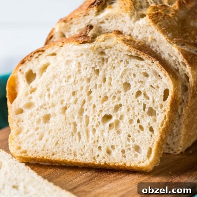 Homemade Sourdough Bread Recipe with Starter 16 Sourdough bread loaf with a slice resting against it.