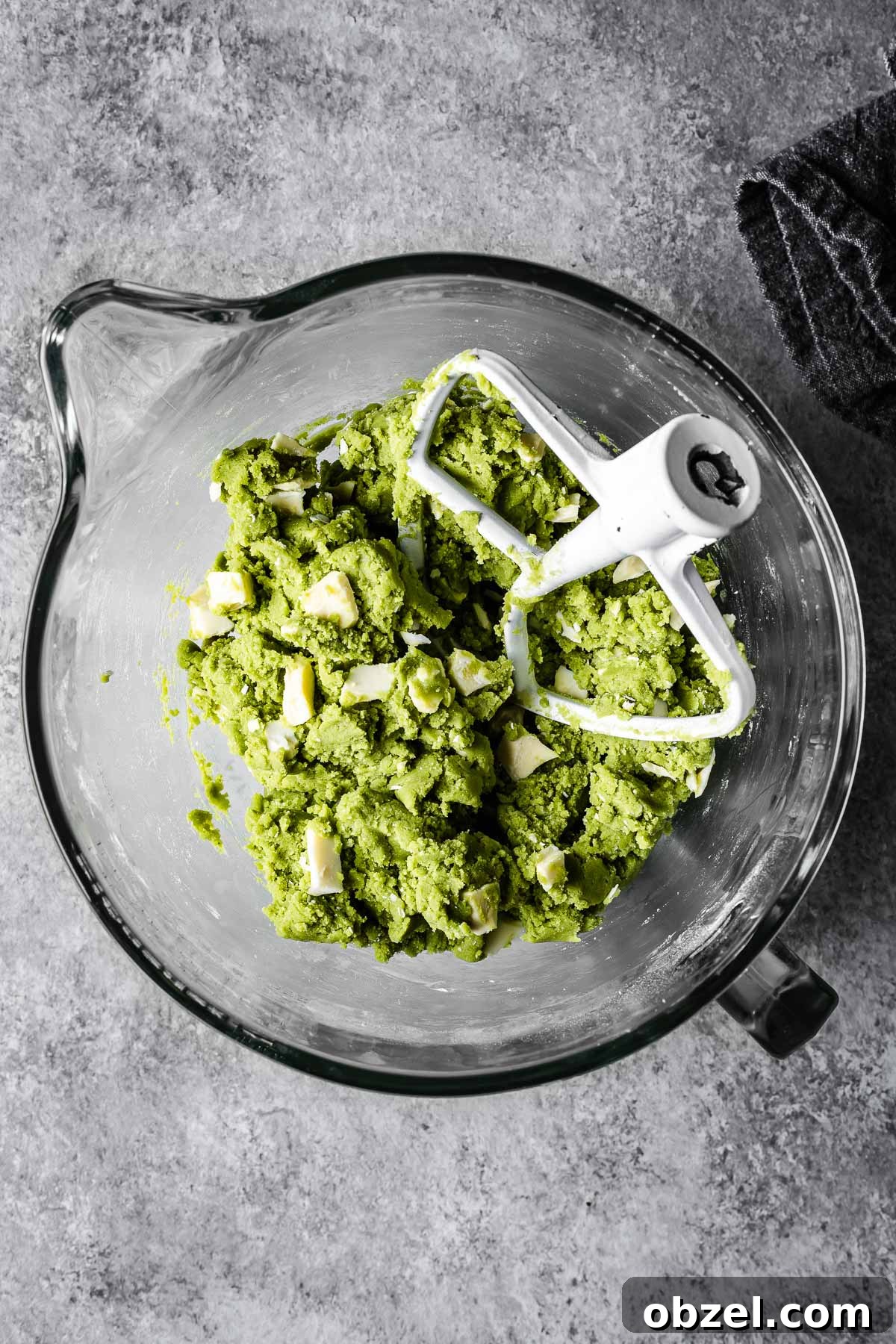 Matcha White Chocolate Cookies Recipe 8 Green cookie dough in a glass mixer with white chocolate chunks added in.