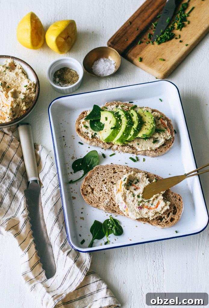veggie cream cheese on toast with avocado spinach on white tray with knife, salt and pepper