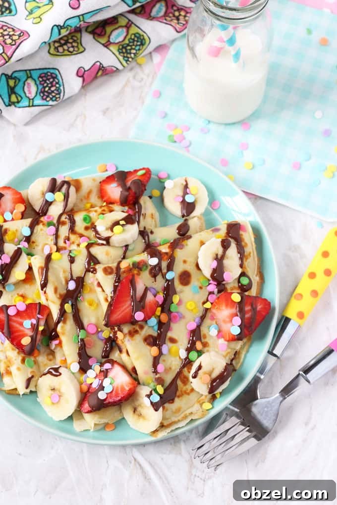Confetti Sprinkle Pancakes Recipe: Fluffy Party Pancake Stack 3 confetti sprinkled pancakes on a blue plate topped with chopped strawberries and chocolate sauce