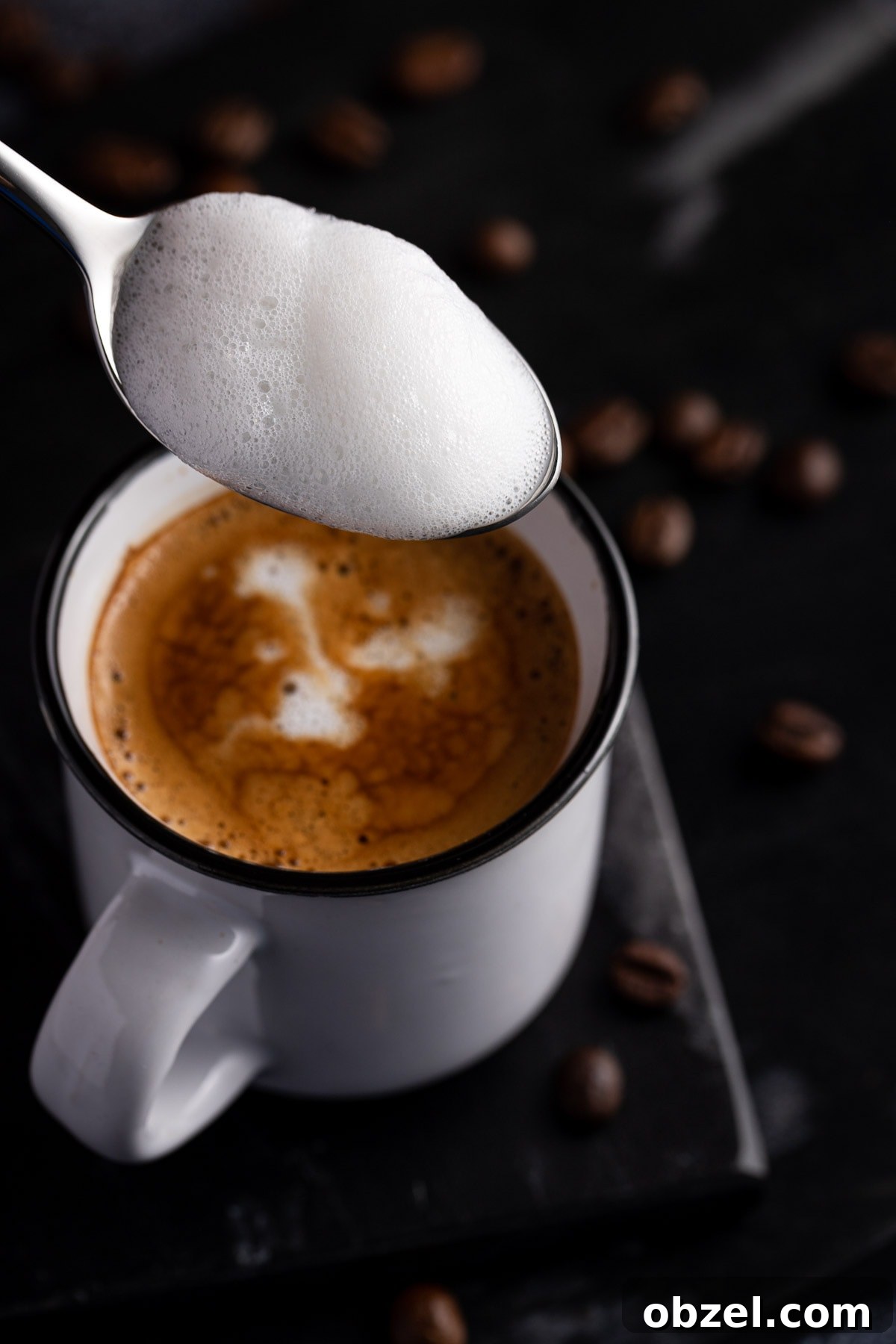 Starbucks Doppio Caffeine Calories and Price 5 A scoop with a scoop of milk foam, held above a small white cup filled with espresso.