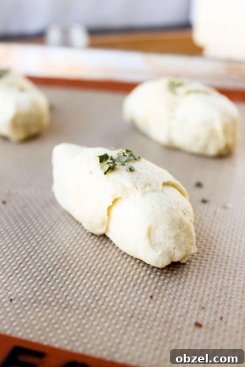 Cheesy Bacon and Pepper Jack Stuffed Crescent Rolls 11 unbaked stuffed crescent roll on a baking sheet.