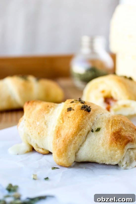 Cheesy Bacon and Pepper Jack Stuffed Crescent Rolls 6 a golden crescent roll on wax paper, topped with chives.