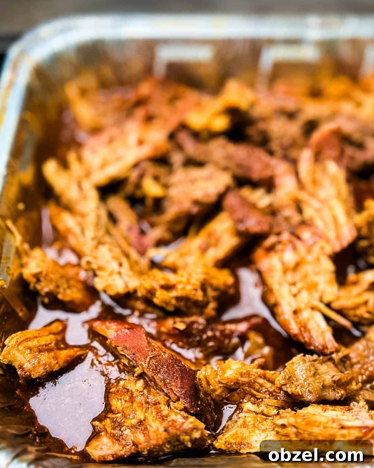 Smoked Pulled Pork Loin on a Traeger Grill 7 An aluminum pan filled with shredded smoked pork loin.