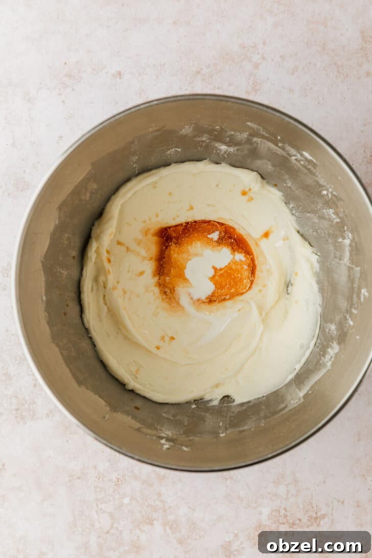 Pumpkin Spice Mini Bundt Cakes 14 A silver bowl of cream cheese frosting with vanilla for pumpkin mini bundt cakes.