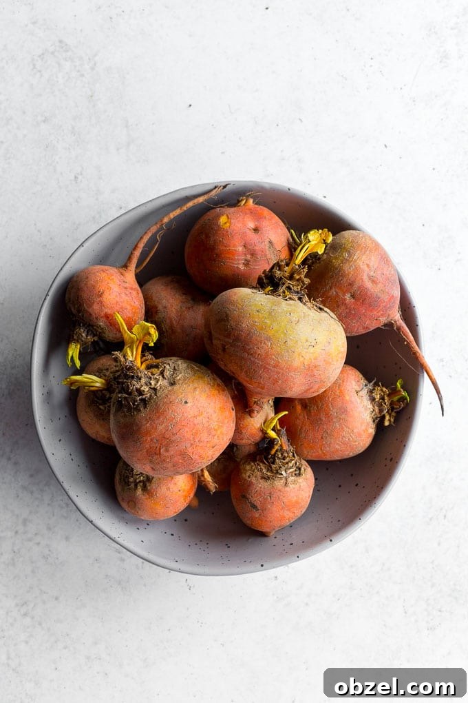 Vegan Golden Beet Soup with Carrot and Ginger 3 Large bowl of unpeeled golden beets on a light coloured surface.