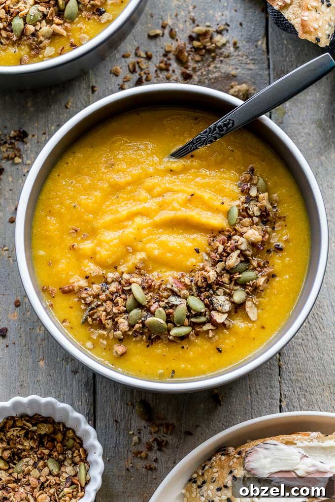 Vegan Golden Beet Soup with Carrot and Ginger 5 Up-close overhead view of golden beet soup in a grey bowl with granola sprinkled on top.