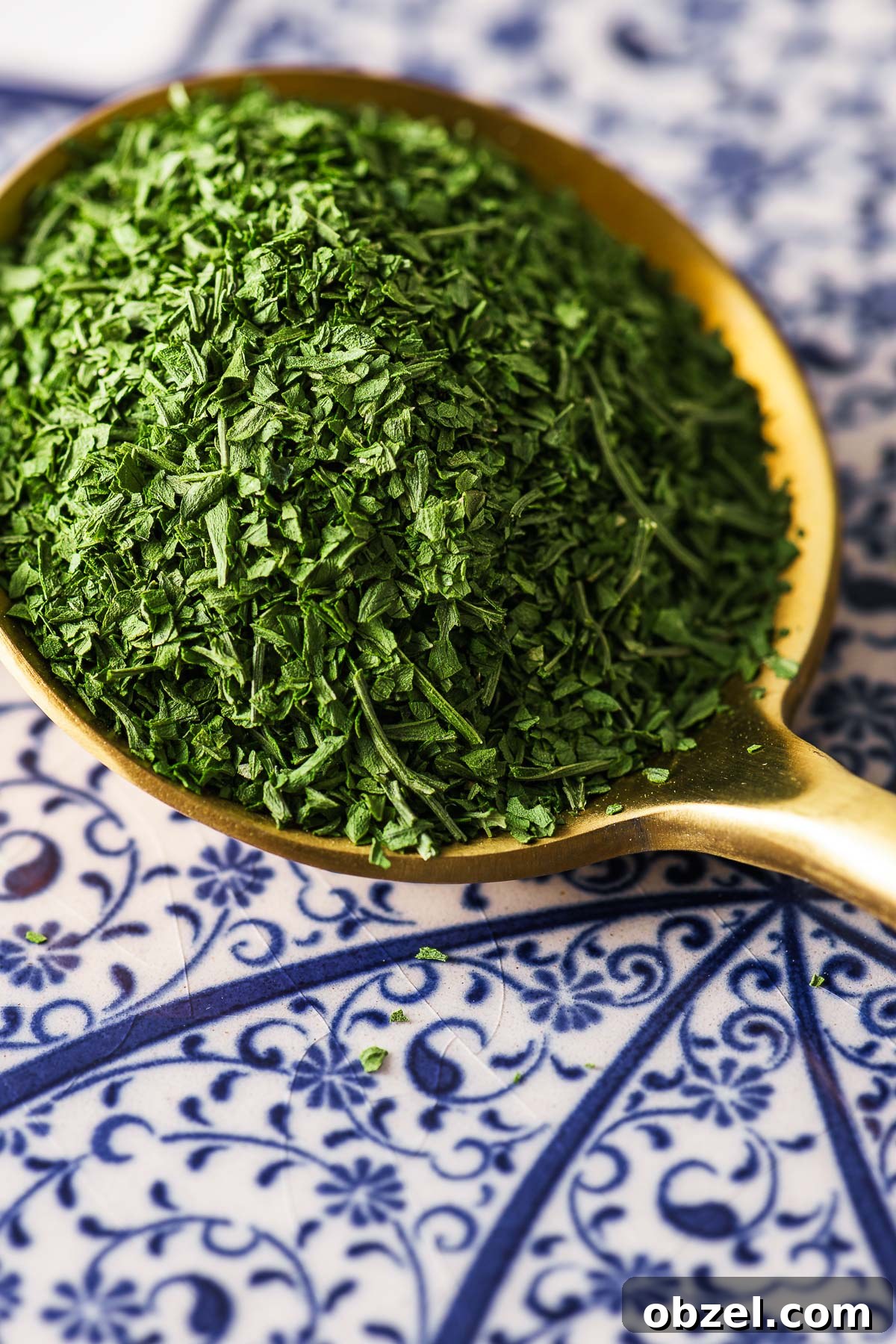 How to Dry Parsley in the Oven for Crisp, Flavorful Herbs 3 A close-up of a tablespoon of dried parsley on a patterned background.