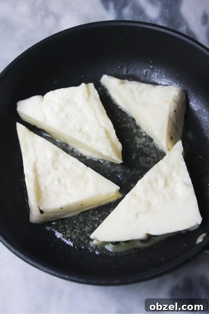 Honey and Harissa Glazed Halloumi Recipe 7 4 wedges of halloumi in a small black pan.